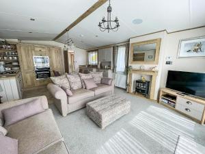 a living room with two couches and a tv at Modern Caravan With Large Decking Area, Ref 60057Ch in Saxmundham