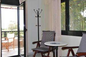 a room with two chairs and a table and a balcony at Pagonis Studios in Lixouri