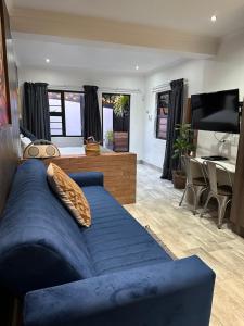 a living room with a blue couch and a dining room at RElaxed city living in Port Elizabeth