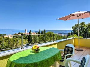 a table with a bowl of fruit on top of a balcony at Wonderful Brsec Apartments with Sea View and Shared Pool in Brseč +14 photos
