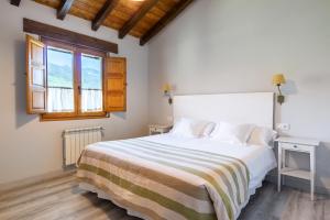 a bedroom with a large white bed and a window at Casa 8plazas, 7km de la playa La Franca, Asturias in Boquerizo