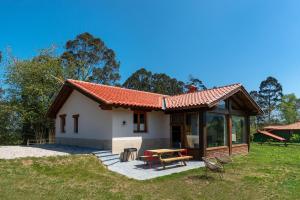 a small house with a picnic table in the yard at Casa 8plazas, 7km de la playa La Franca, Asturias in Boquerizo