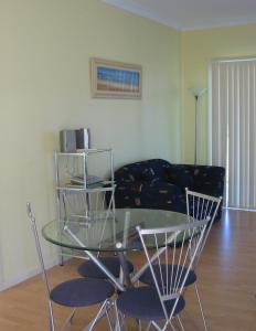 uma mesa de vidro e cadeiras numa sala de estar em Lindsays of Kangaroo Island em Penneshaw