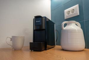 a coffee maker on a table next to a vase at Diolanth traditional house in Koskinou