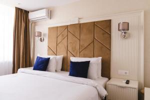 a hotel room with two beds with blue pillows at Hotel Belvedere in Eforie Nord