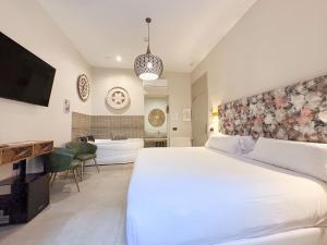 a bedroom with a large bed and a bath tub at Akla Hotel Badajoz in Badajoz