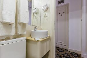 a white bathroom with a sink and a mirror at Hotel Belvedere in Eforie Nord +12 photos