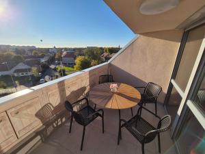 a patio with a table and chairs on a balcony at Jókai Corner Apartment in Debrecen