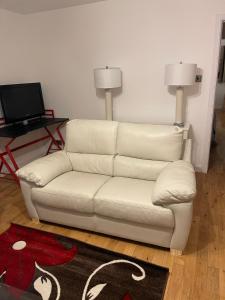 een witte bank in een woonkamer met een televisie bij Morrisons 2 weeks plus city centre 2 bedroom Apt in Aberdeen