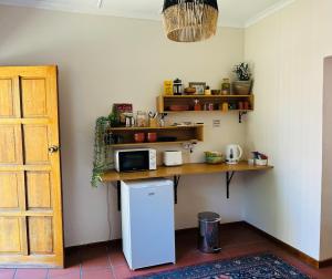 a kitchen with a counter with a microwave and a refrigerator at Casa No 85 Accommodation in Harrismith
