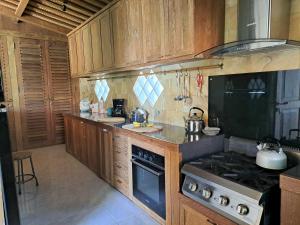 JarakanにあるVilla imalee - éco-conceptの木製のキャビネットとコンロ付きオーブンを備えたキッチン