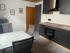 a kitchen with a table and a stove top oven at Ferienwohnung Fürst in Ehringshausen