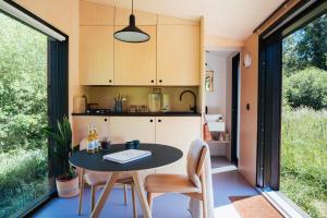 una cucina e una sala da pranzo con tavolo e sedie di Wild Cabins Kinvara a Cloonnasee