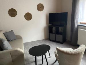 a living room with a couch and a tv at Ferienwohnung Fürst in Ehringshausen