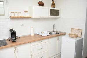a kitchen with white cabinets and a sink at Vikendica Čeperković #1 in Kopaonik