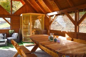 a large wooden table in a porch of a cabin at Leśna Ostoja in Lubawka