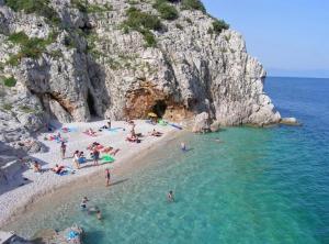 a group of people on a beach in the water at Chic and Cozy Brsec Apartment with Sea View in Brseč