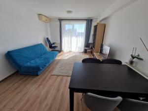 a living room with a blue couch and a table at Airplane Residence 1 in Otopeni