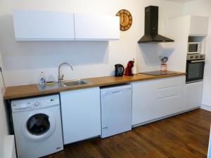 a kitchen with white cabinets and a washing machine at Le Chellois appartement La Bresse in La Bresse +12 photos