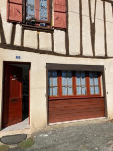 a building with a door and a window at Chez Stella 1 pièce canapé lit deux personnes, Cuisine, SDB séparée in Caylus +1 photo