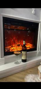 a bottle of wine and a glass in front of a fireplace at Nova Panorama in Vrdnik