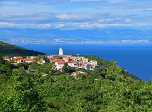 a small town on top of a hill next to the ocean at Chic and Cozy Brsec Apartment with Sea View in Brseč