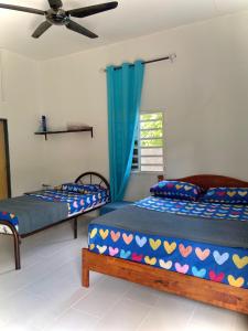 a bedroom with two beds and a window at roomstay batu buruk in Kuala Terengganu