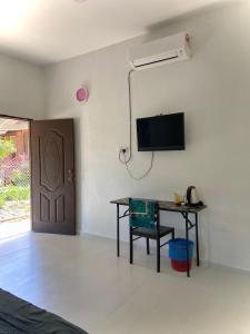 a room with a desk and a door and a television at roomstay batu buruk in Kuala Terengganu