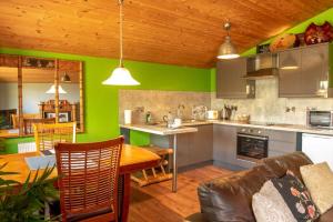 a kitchen with green walls and a wooden ceiling at Wild Oats 14 Yellowtop Country Park in Foggathorpe