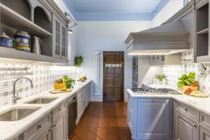 Una cocina con gabinetes blancos y un techo azul. en Villa Dante, en Florencia 32 fotos más
