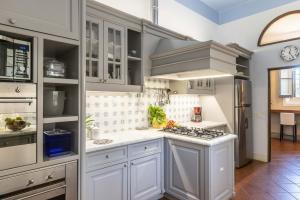 Una cocina con gabinetes blancos y una estufa. en Villa Dante, en Florencia