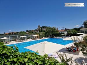 a large swimming pool with umbrellas and chairs at La Corte del Podestà in Sarteano