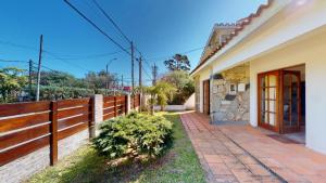 a house with a fence and a walkway at Casa chalet , Centro de La Paloma in La Paloma +1 photo