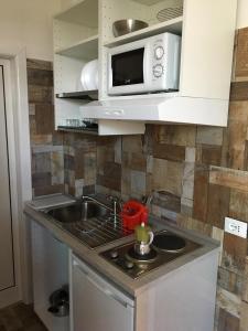 a kitchen with a sink and a microwave at Ducati 8 Studio in Bologna