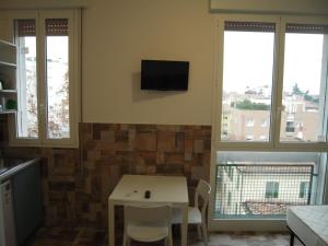 a kitchen with a table and a tv on the wall at Ducati 8 Studio in Bologna