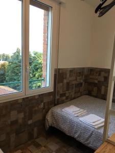 a small bedroom with a bed and a window at Ducati 8 Studio in Bologna