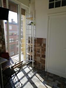 a room with a door and a chair and a balcony at Ducati 8 Studio in Bologna