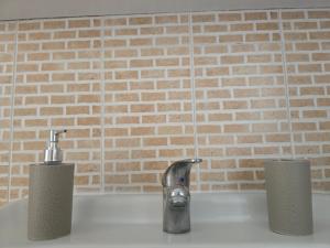 encimera de cocina con fregadero con grifo y 2 velas en Brother's House, en Salerno