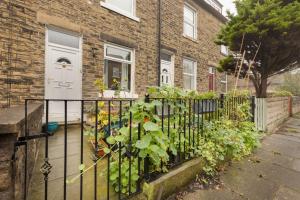 a fence with a bunch of plants in front of a house at Cosy vibe in Saltaire