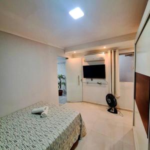 a bedroom with a bed and a flat screen tv at Casa aconchegante no centro de Remanso in Remanso