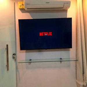a television on a wall with the words netflix at Casa aconchegante no centro de Remanso in Remanso +3 photos