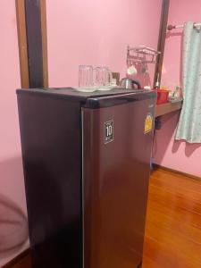 a black refrigerator with wine glasses on top of it at Kanitta Homestay kohyaonoi in Ban Bang Chak