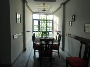 ein Esszimmer mit Tisch und Stühlen und einem Fenster in der Unterkunft SWAT HiLL ViEW RESORT-only for families in Swat