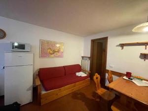 Una sala de estar con un sofá rojo y una mesa. en Appartamento in Residence Cervinia Due, en Breuil-Cervinia 14 fotos más