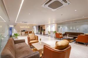 a lobby with couches and chairs in a building at Saltstayz Premier - Golf Course Road & Sector 42 in Gurgaon
