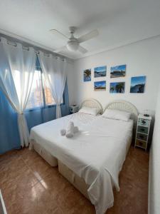 a bedroom with a white bed and a window at Espanhouse Sonia in La Zenia Playas de Orihuela in Orihuela