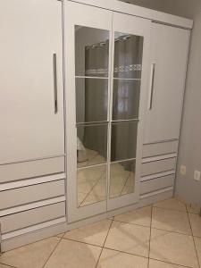 a white cabinet with glass doors in a room at The House Foz Do Iguaçu Cataratas e Paraguai in Foz do Iguaçu