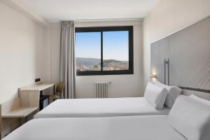 a white bedroom with a large bed and a window at B&B HOTEL Vigo in Vigo +41 photos
