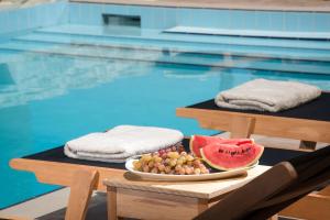SívasにあるPhaistos Villas - Crete Poolside Luxury Retreatsのスイミングプール横のテーブルに盛り付けられた果物