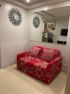 a red couch in a room with a mirror at Arkes Residential Condo Unit Rental in Baguio